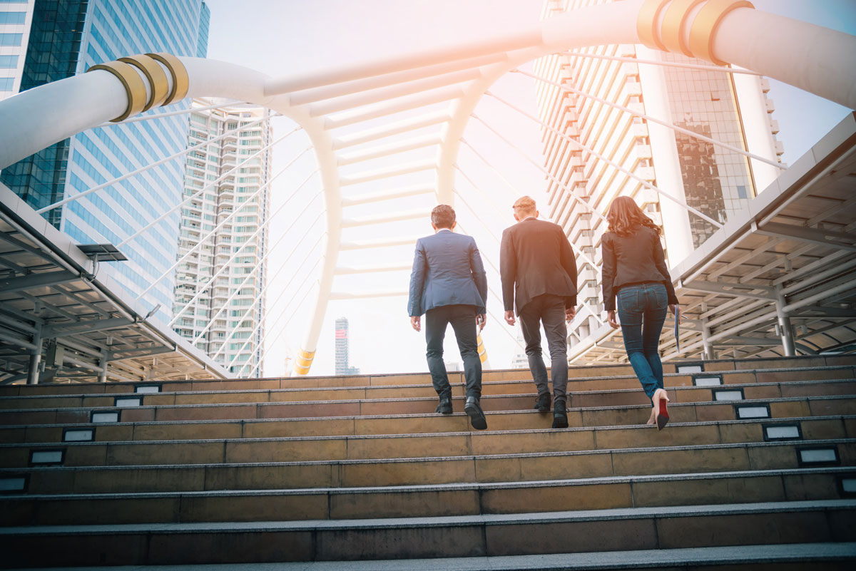 Rear view of business team climbing stairs go to a city. Business concept