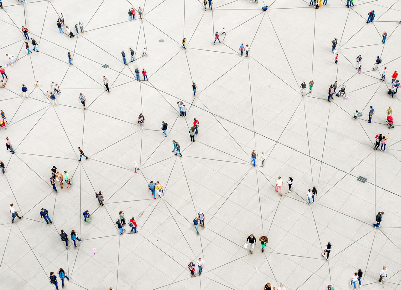 Overhead view of people crossing a geometric plaza