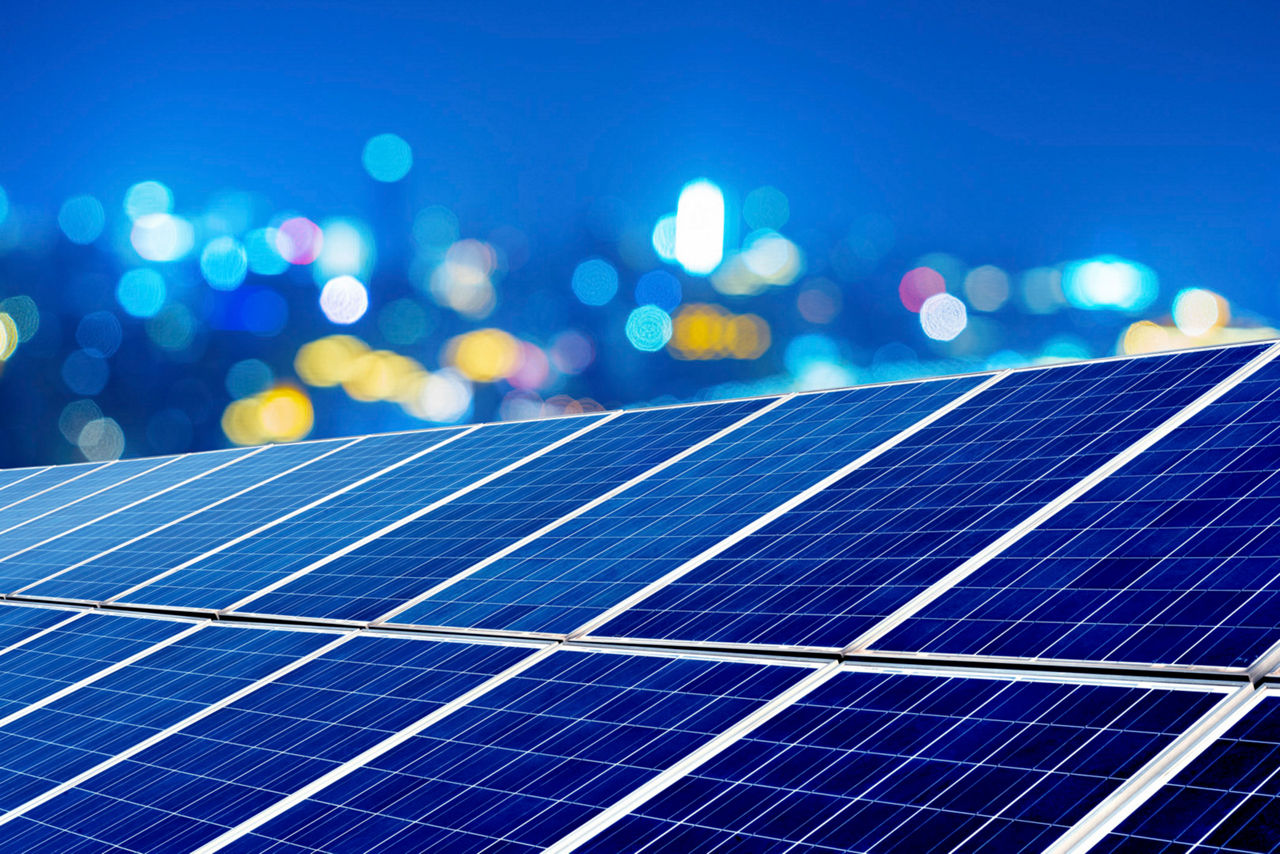 Photovoltaic panels in front of city night lights