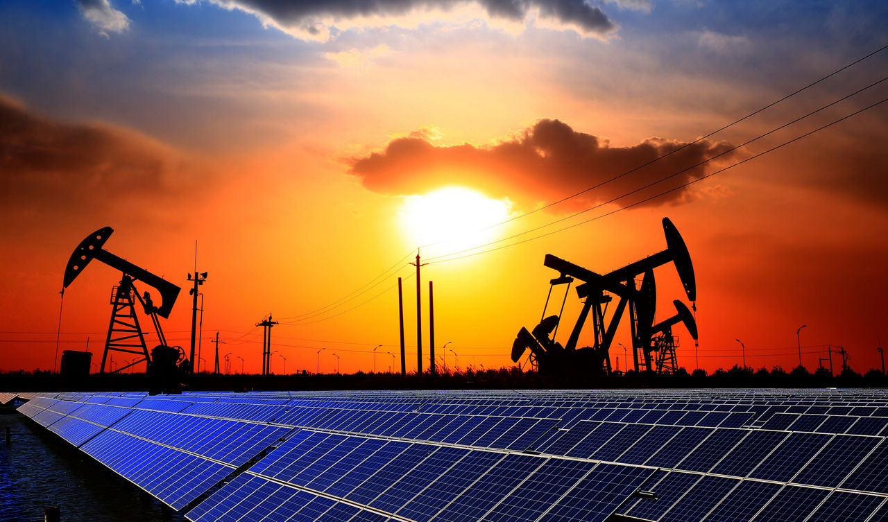 Oil pump with solar panels and the sunset