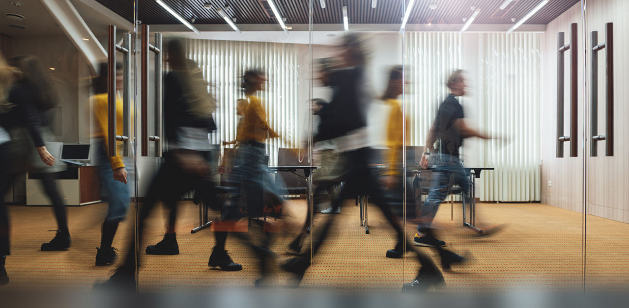 Businesspeople walking at modern office. Group of business employees at coworking center. Motion blur. Concept work process. Wide image