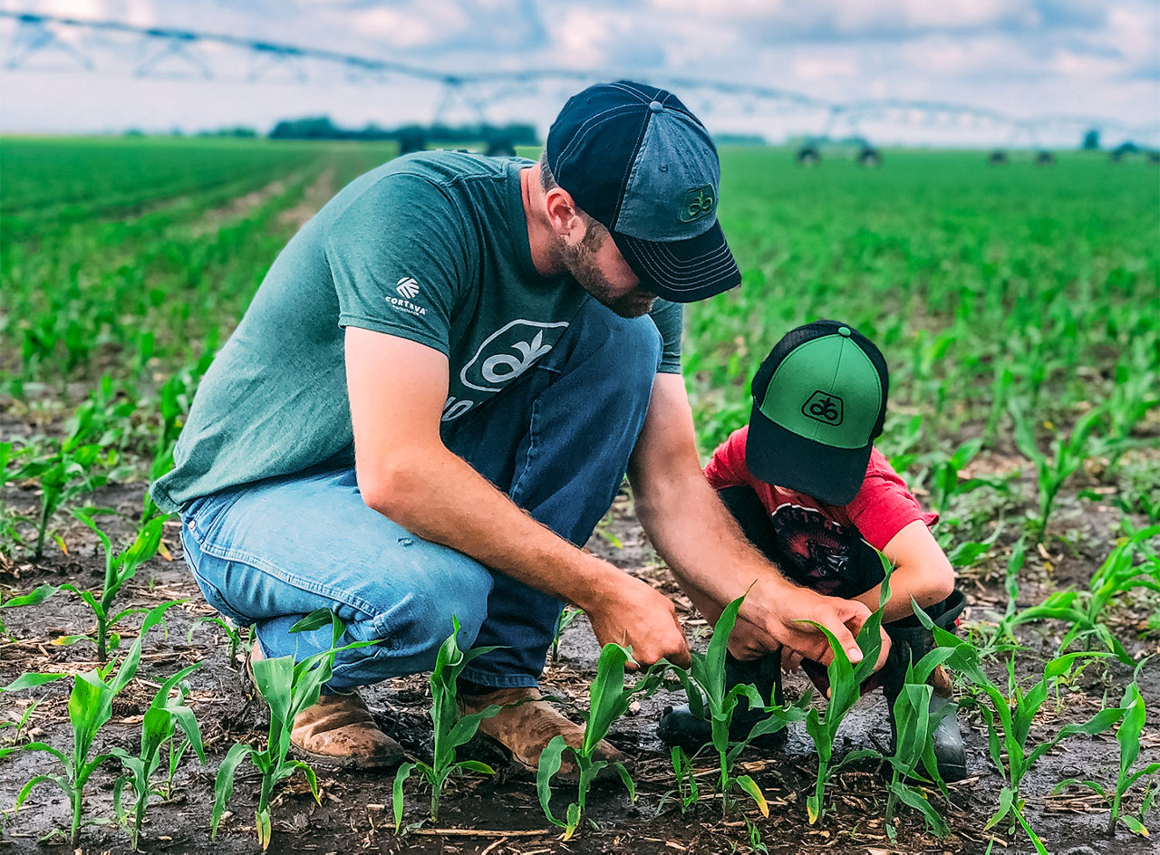 Photo - man and child in field - examining crops