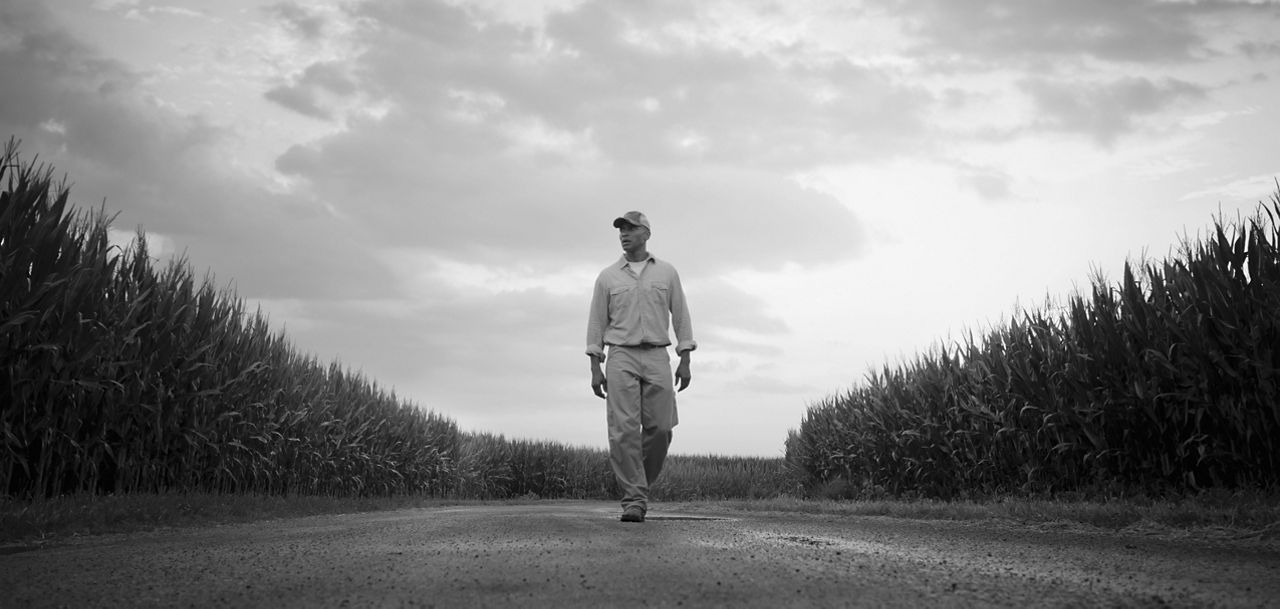 man walking thorugh field