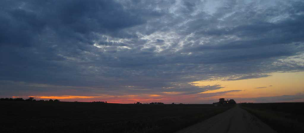 Sunset - clouds and farm machinery in background