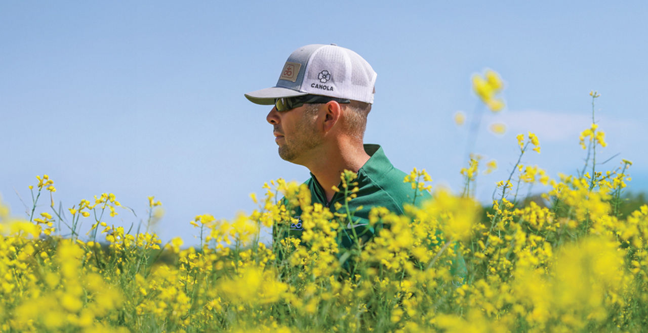 Farmer standing in a field of winter canola