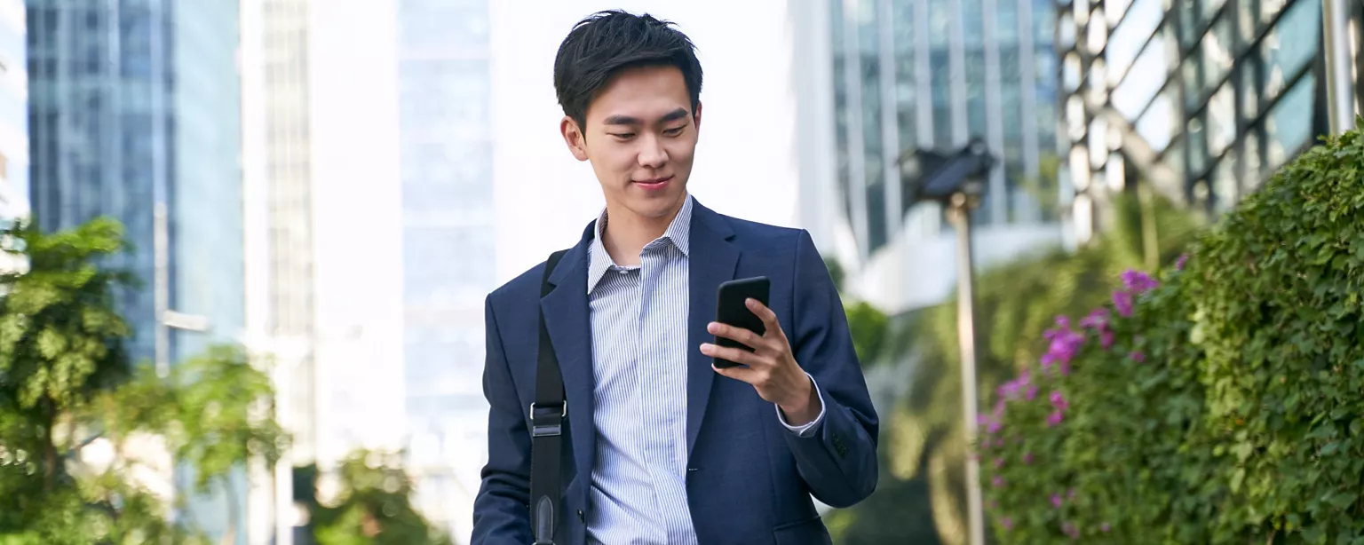 businessmen checking phone message outside the building