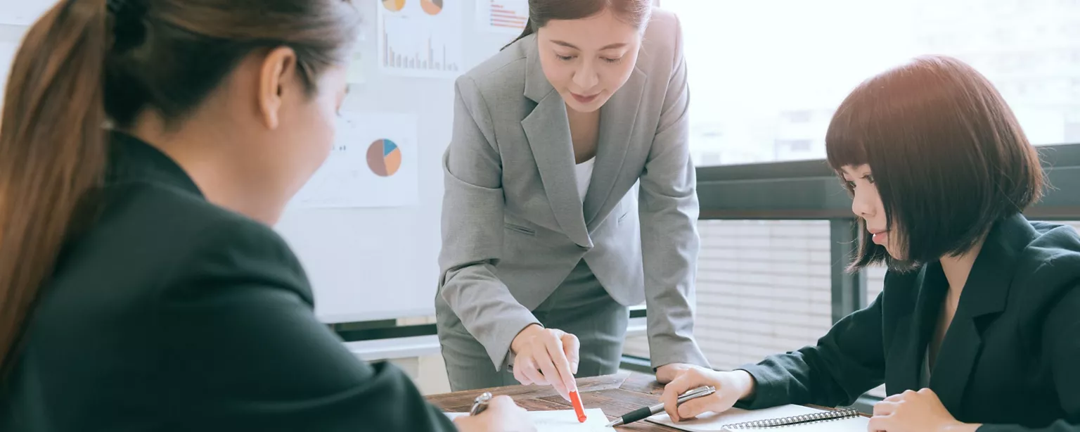 three working women discussing financial reports in a meeting room
