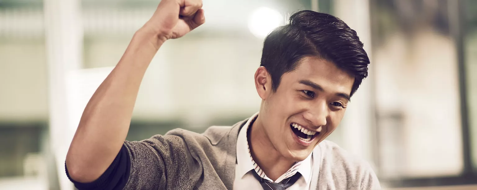 A businessman raises his arm in excitement