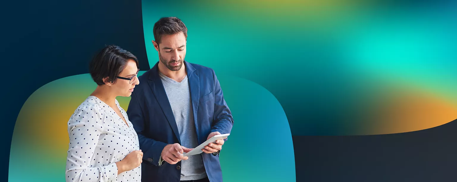 A marketing professional reviews a project with a colleague while collaborating against a colorful gradient background.