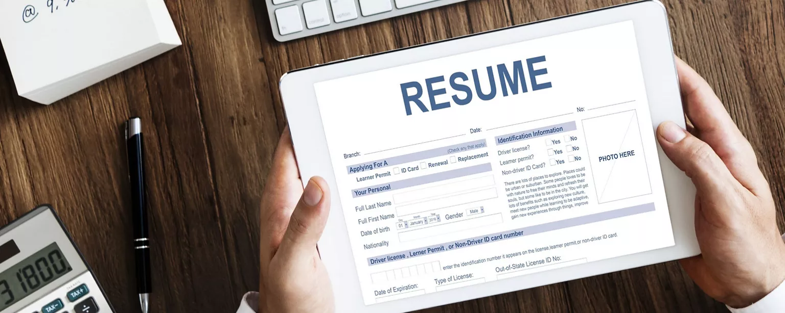 A business person holding a pad showing a resume