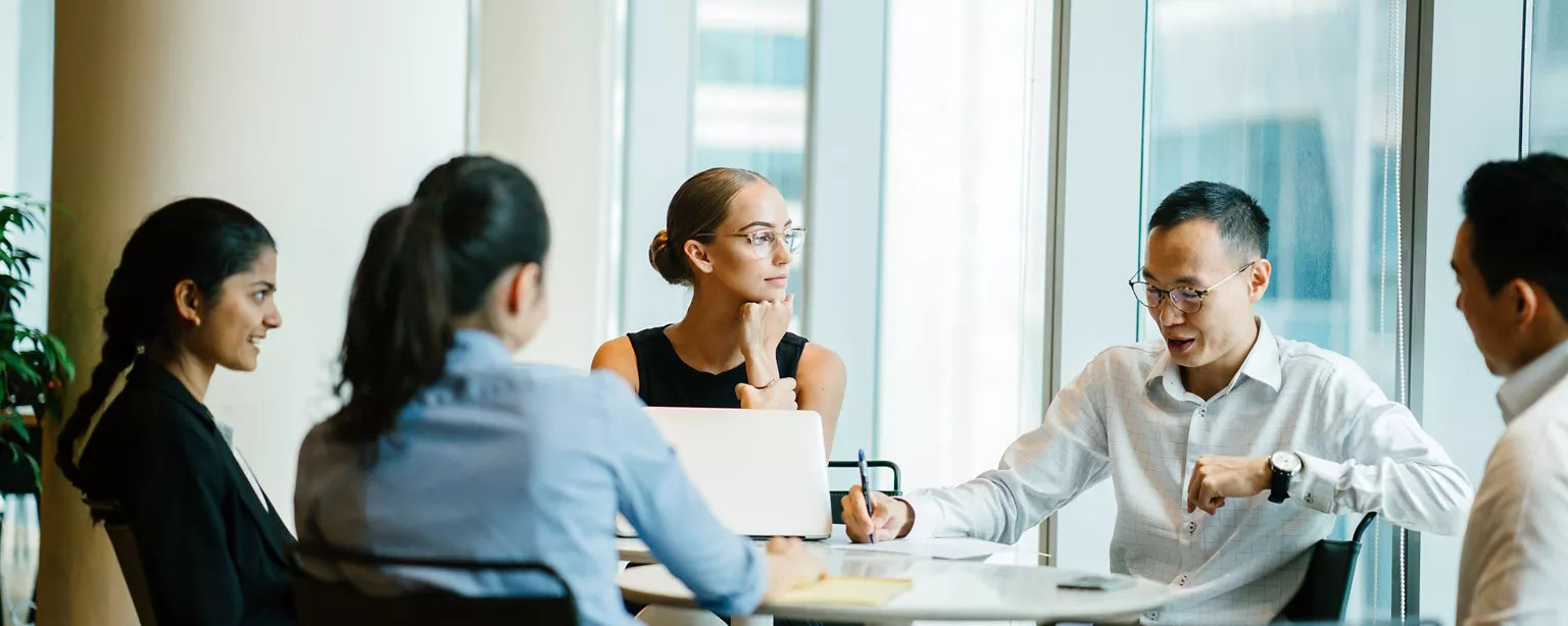 A manager and their team holding a meeting in a conference room