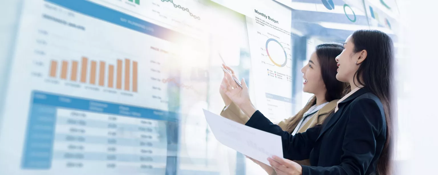 Two businesswomen talking in the front of the data report