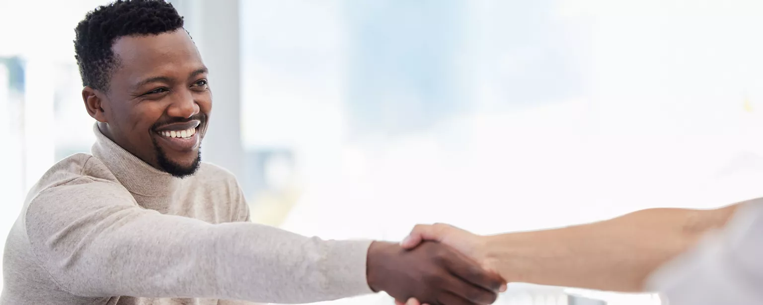 A new employee shakes hands with a hiring manager.