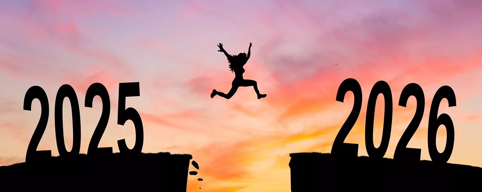 A woman jump between 2025 and 2026 years with a sunset behind her symbolizing the end of one year and jumping into the new year.