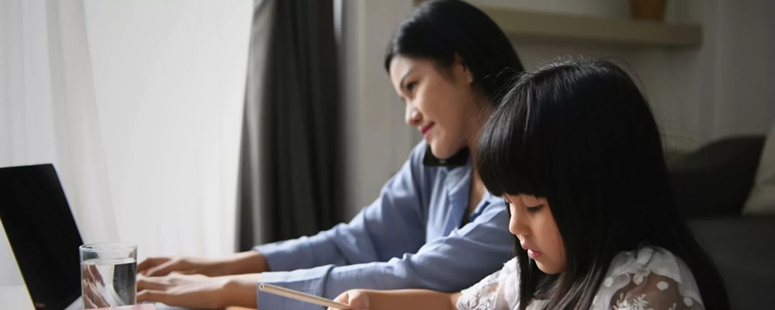 Mother working next to a child