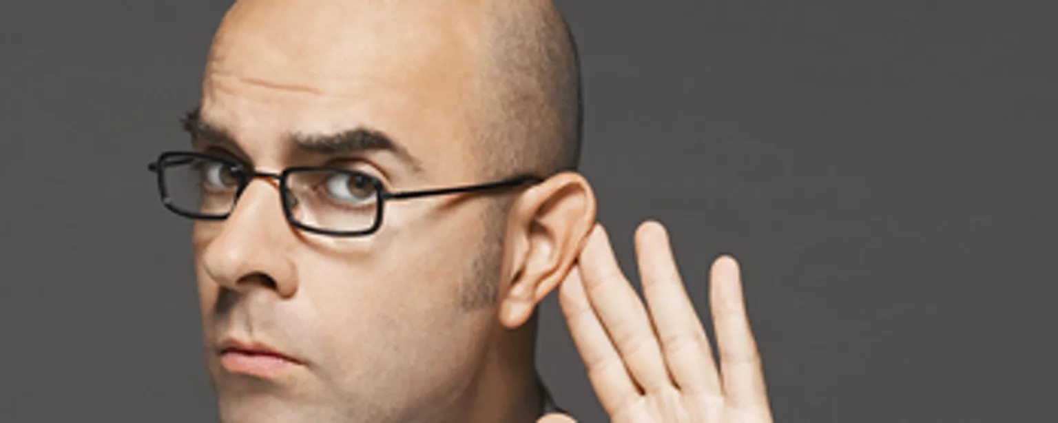 Man holding ear as if to hear what etiquette mistakes managers make