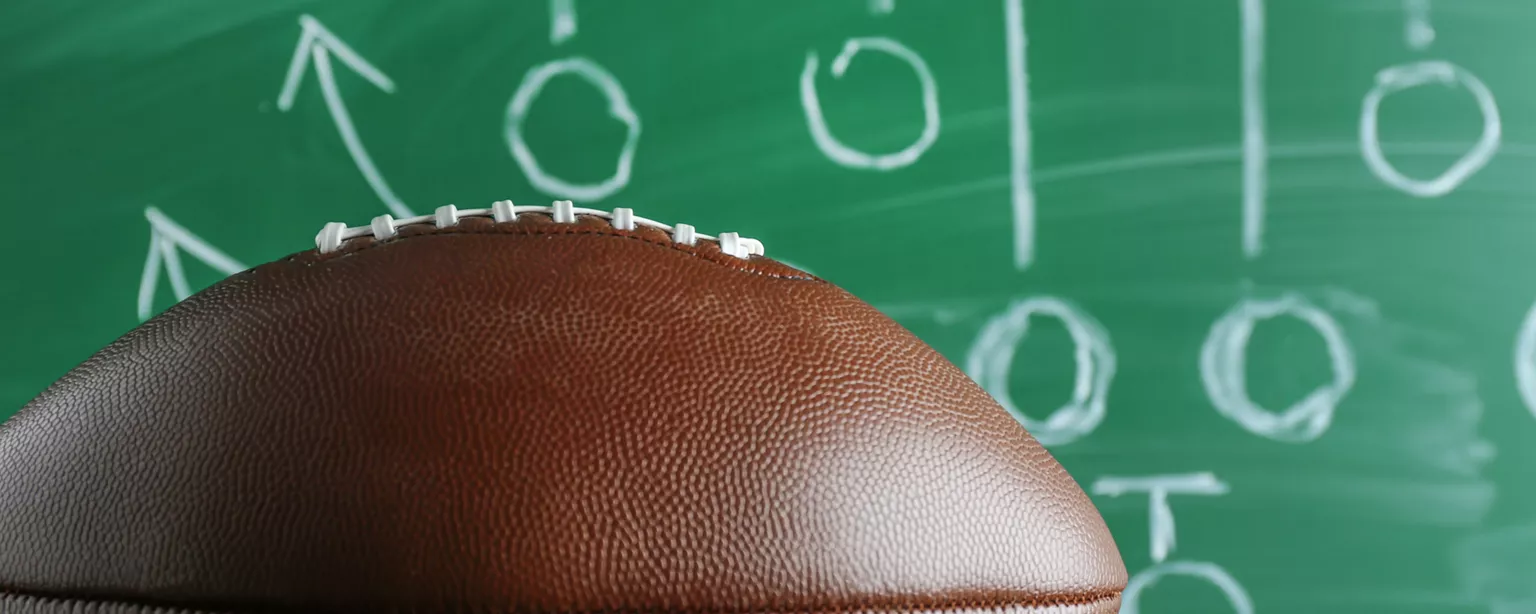 Picture of a football and a chalkboard drawing of a game plan