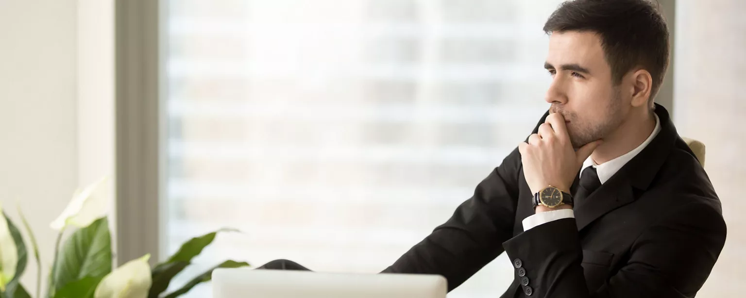 A man sits at his desk in an office environment and reflects on behavioral changes that will help his reputation and boost his influence at work.