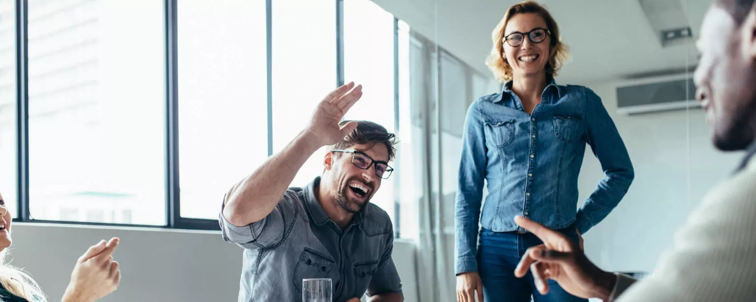 Accountant-Turned-Recruiter Discovers His True Calling — People at work table smiling with hands in the air