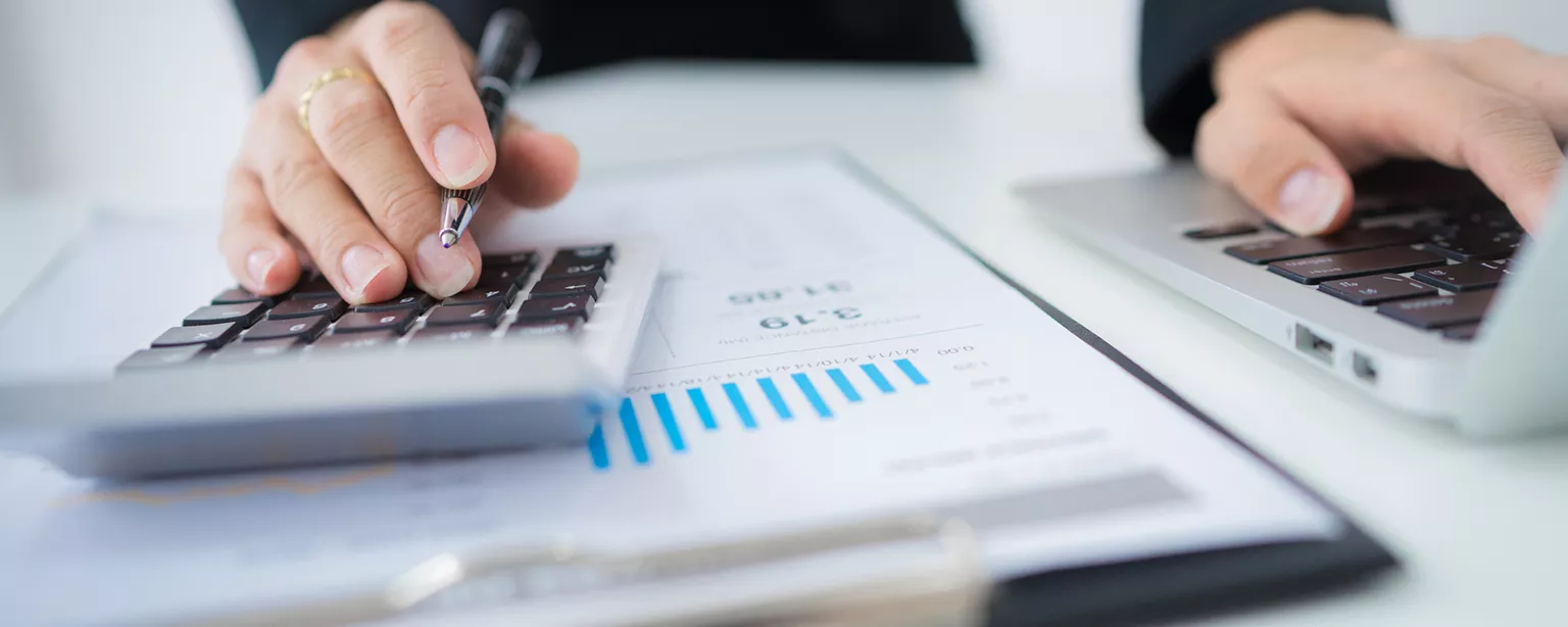 Accounting clerk working with calculator and charts