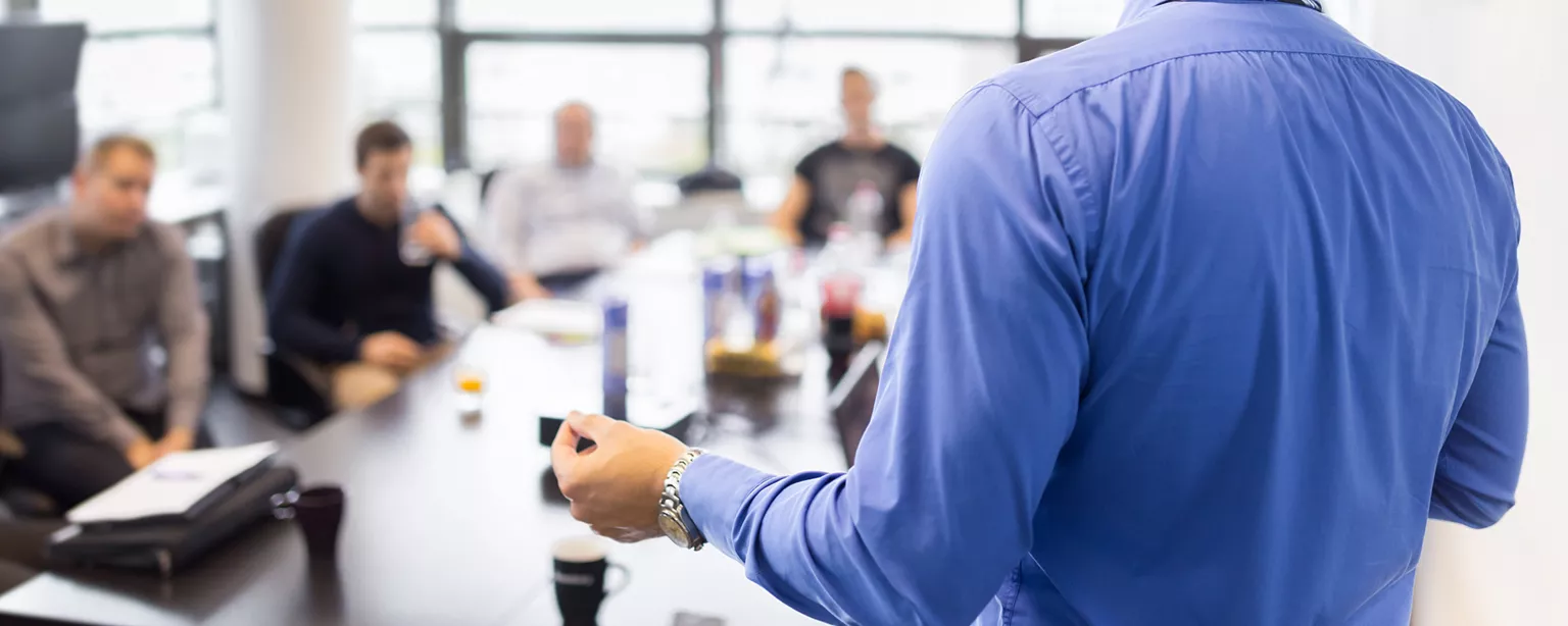 Man offering accounting education to students at table