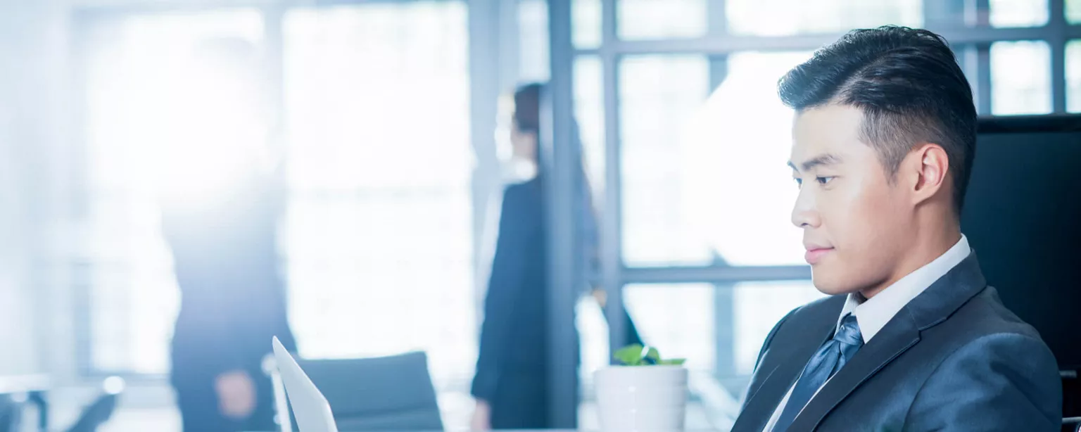 Man in suit with laptop working as accounting manager