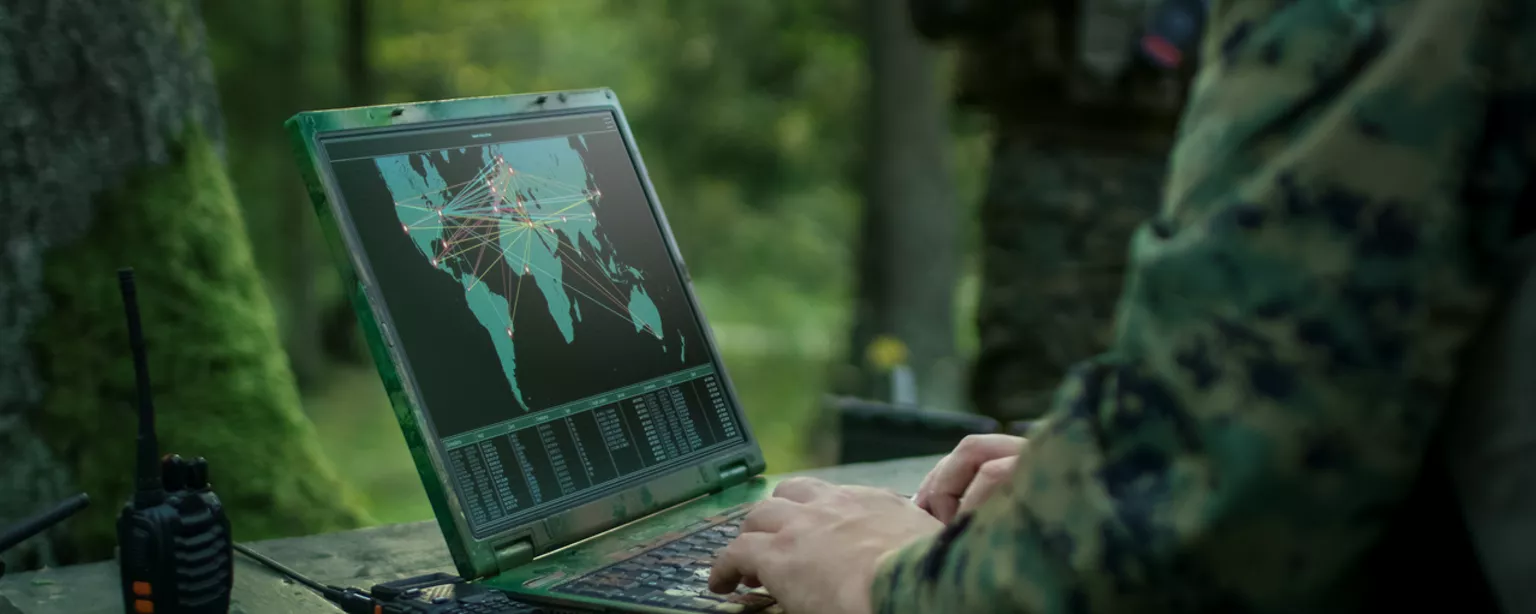 Soldier working with GPS technology on a laptop
