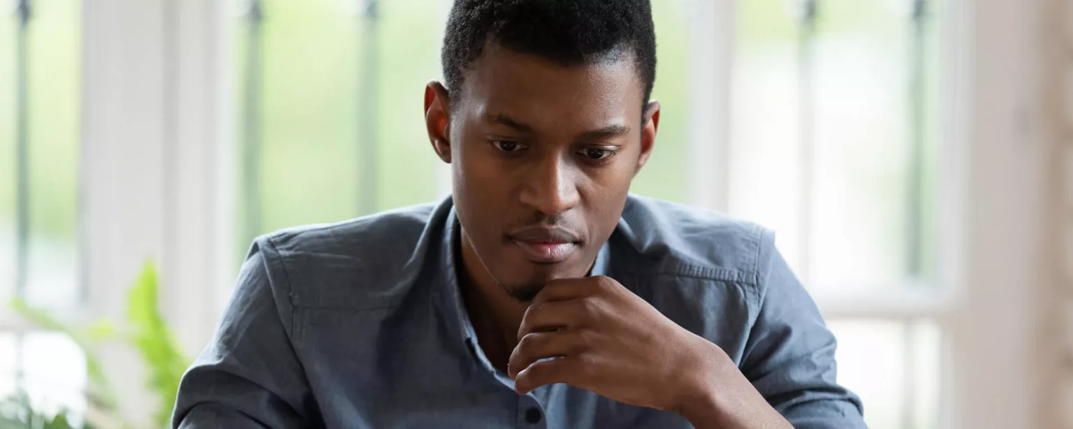 Man looking pensively at laptop