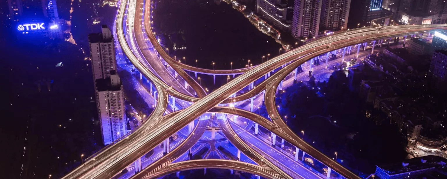 In der Nacht beleuchtete Stadtautobahn mit vielen Abzweigungen
