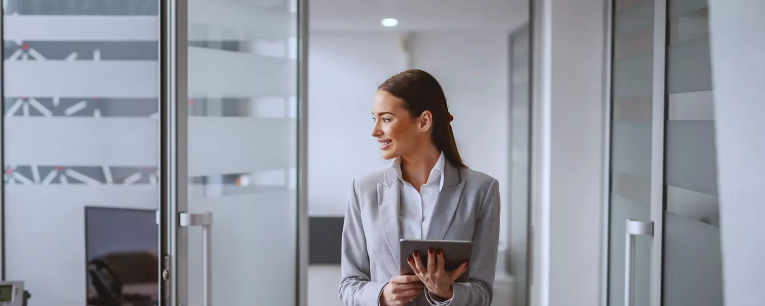 Take the Tech Path to Nonclinical Jobs in Healthcare — woman walking through offices holding electronic tablet