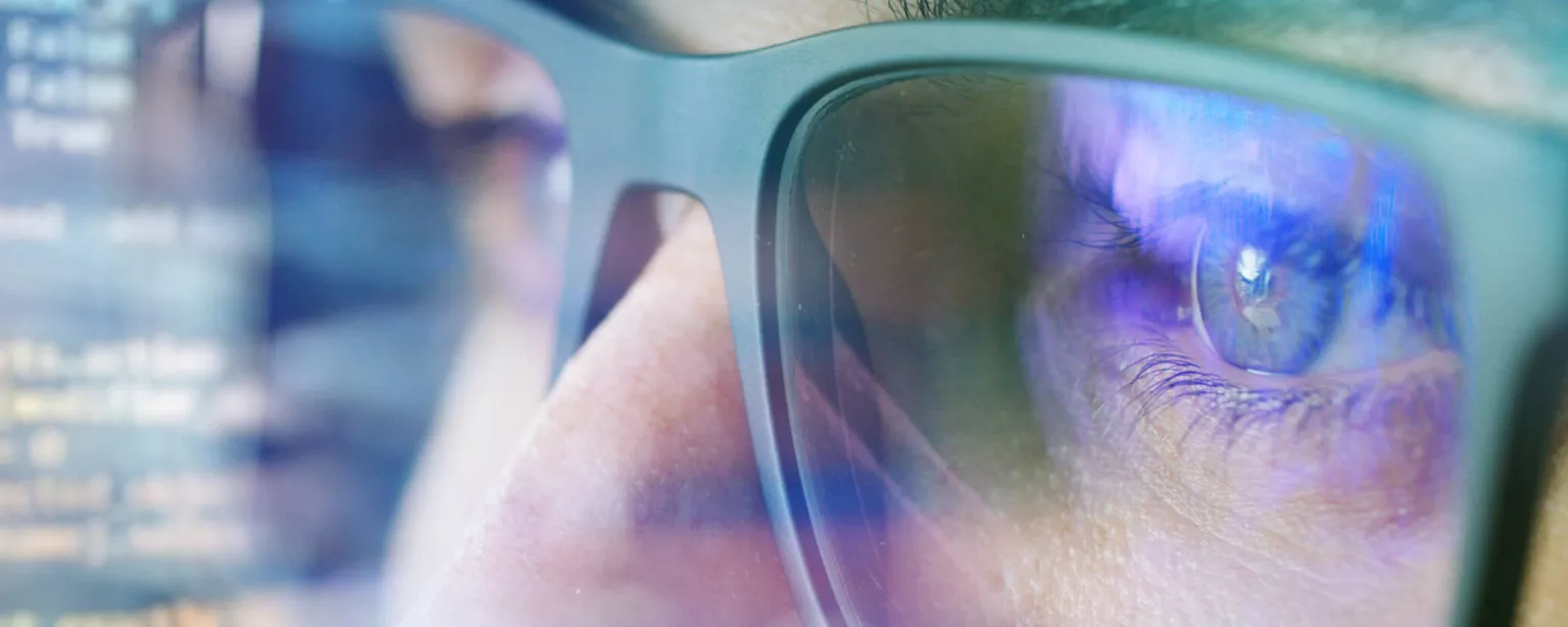 Looking for Contract IT Jobs? Here’s How to Find Them — closeup image of person with glasses looking at computer screen