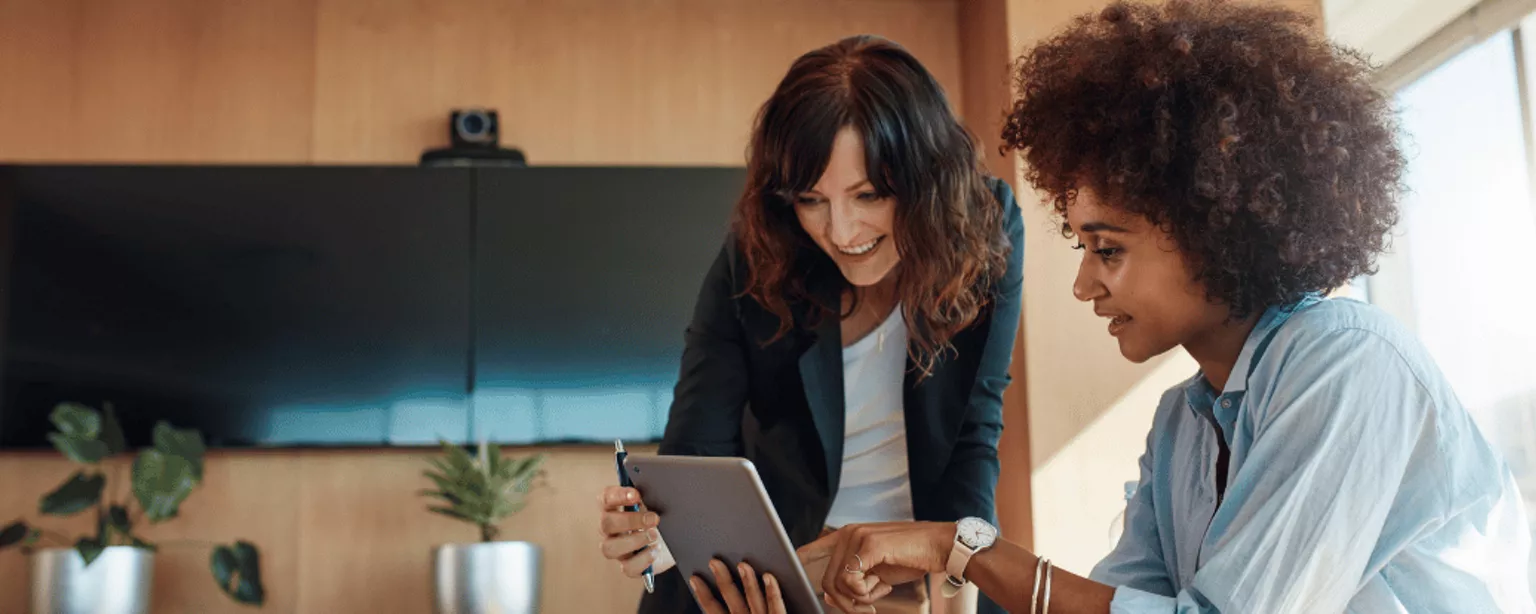 Two women in an office looking at a laptop