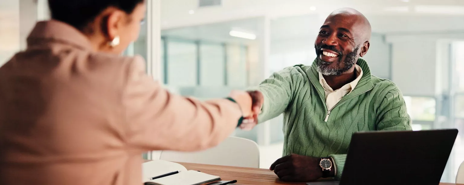 A person shakes a new employee's hand