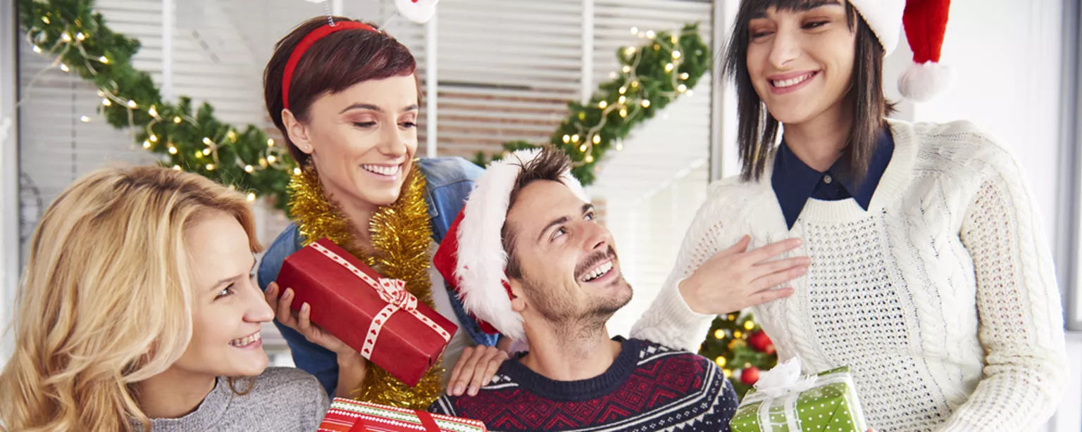 Employees exchanging holiday gifts at the office