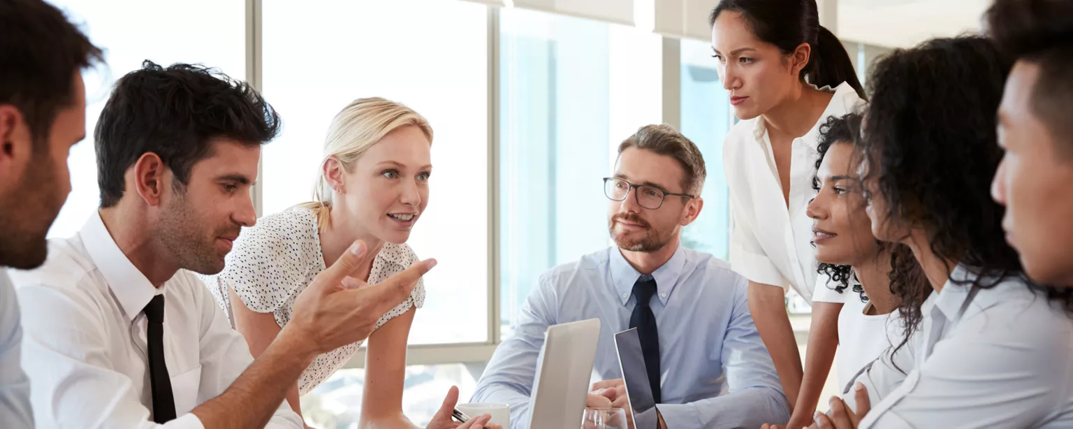 Group of business people meeting around a table discussing a project.