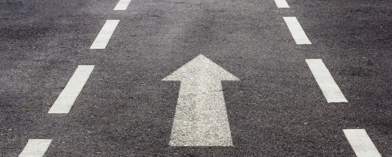 A road with "Career" painted on it in one lane, with an arrow pointing forward.