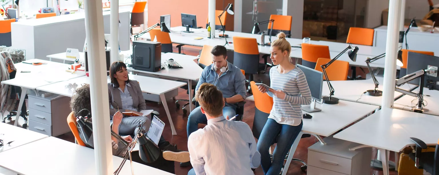 A group of people talk in an office
