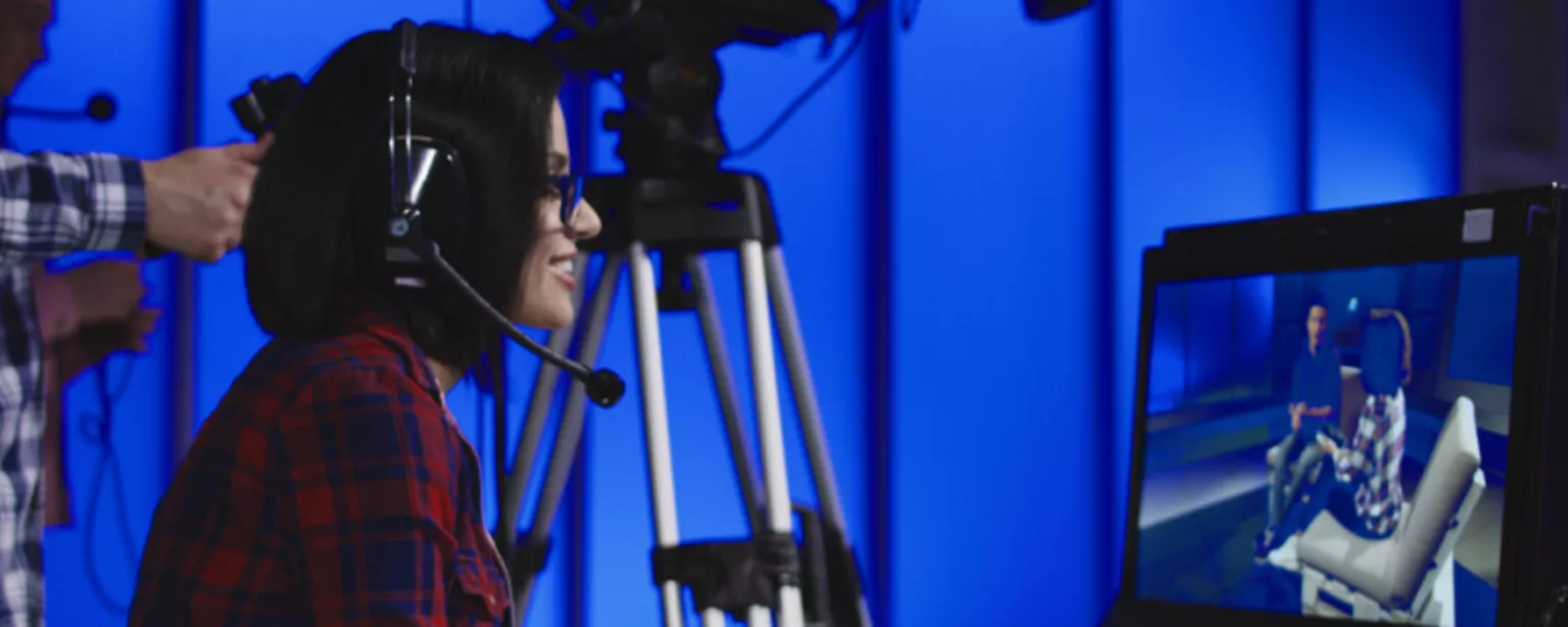 A young woman with a headset, a video producer, working behind the scenes during a video shoot.