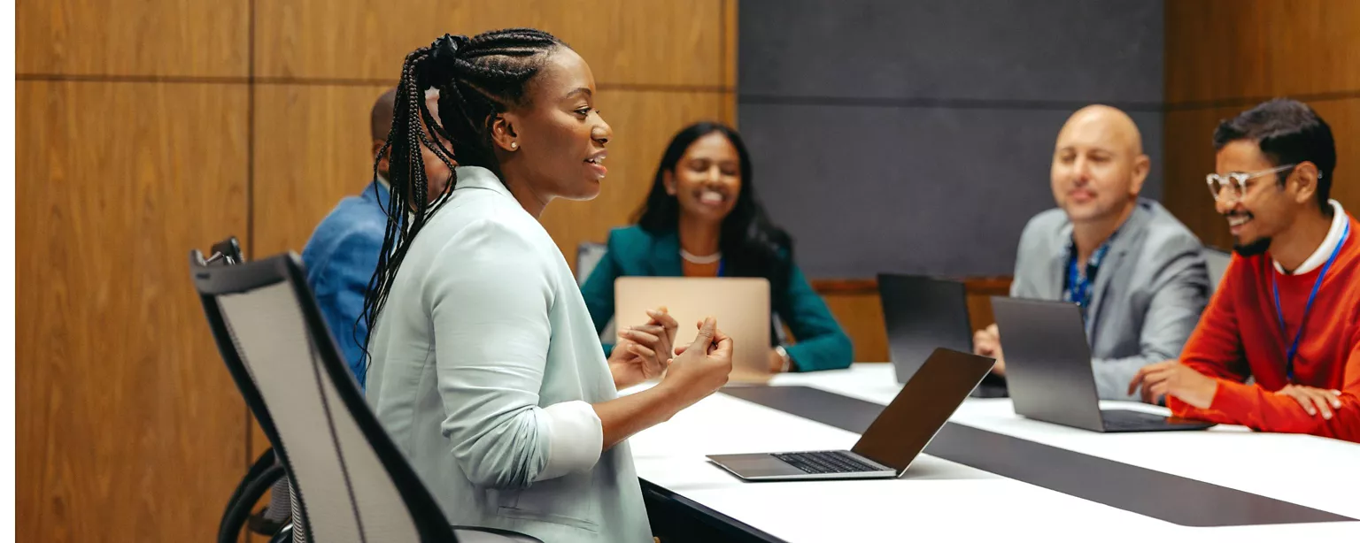 A group of people have a discussion in a meeting room