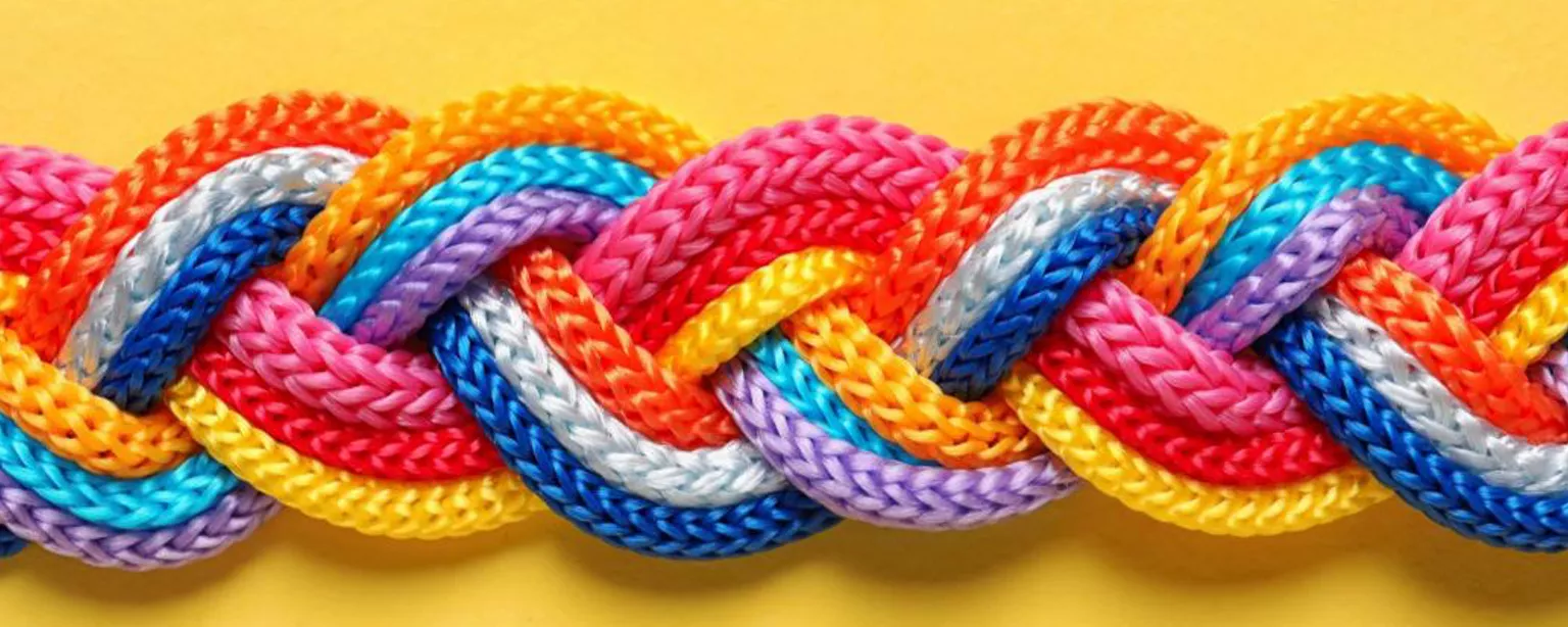 A braid made of many colors of string against a yellow background.