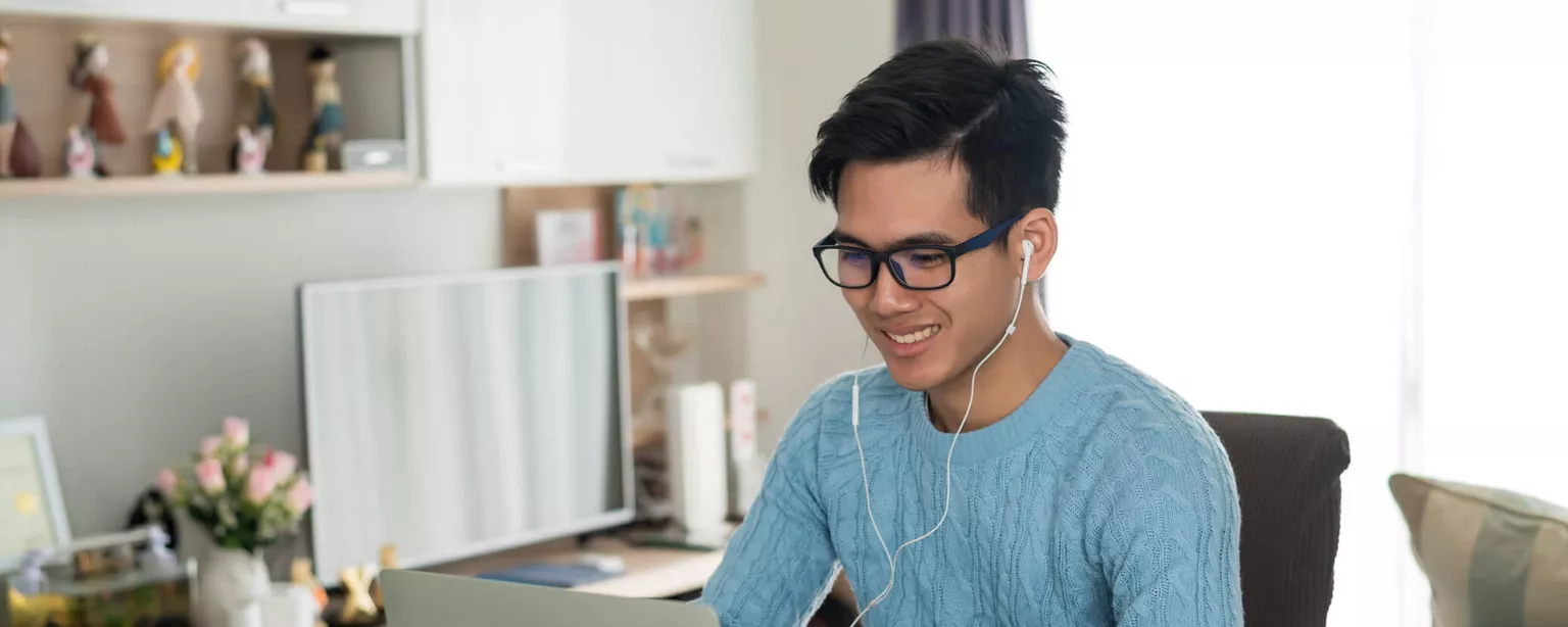 Young man with glasses at office desk with laptop