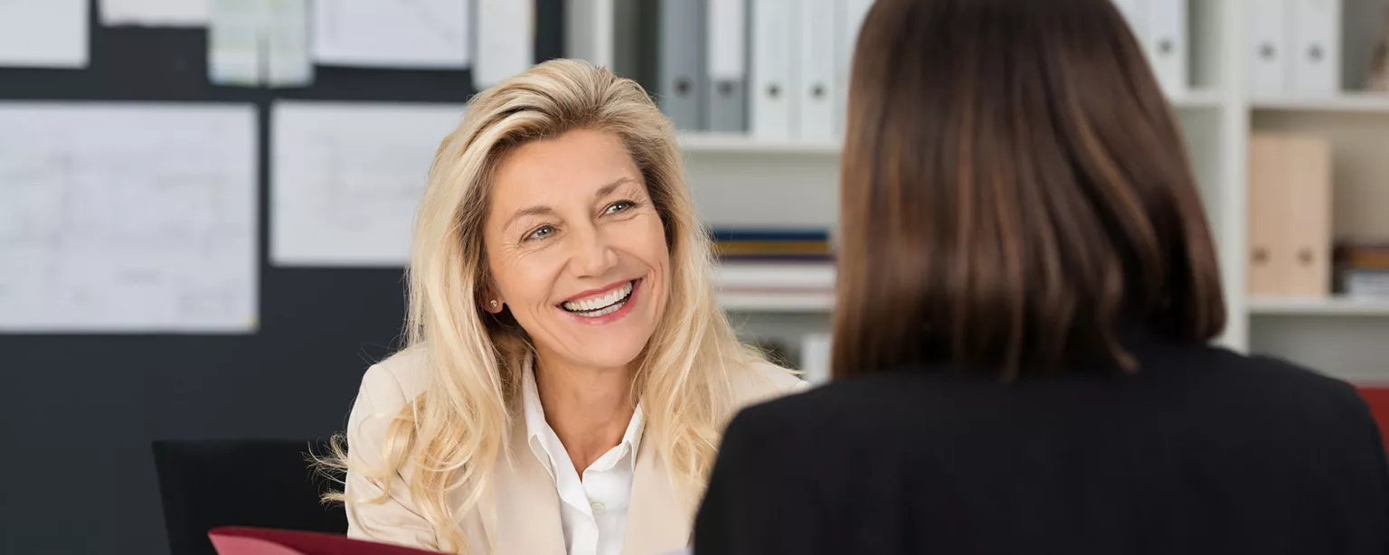 Smiling woman who knows how to make a job offer hands folder to woman
