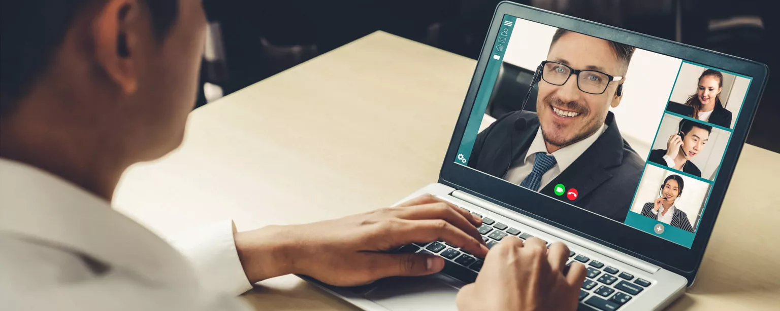 A man with laptop on video call with four professionals.