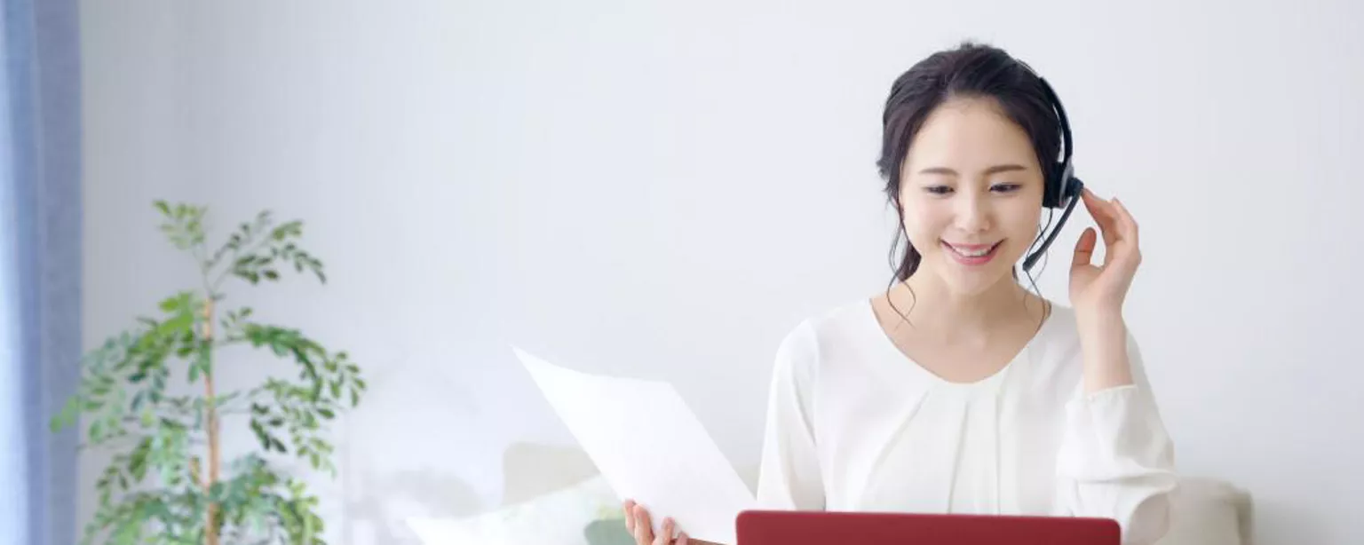 Comment gérer une équipe à distance — femme travaillant à l'ordinateur portable rouge avec des écouteurs