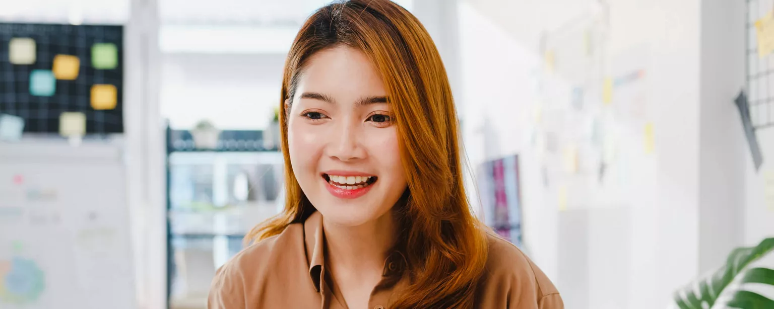 Why Your Marketing and Creative Team May Have Designs on Leaving — smiling woman at computer in office