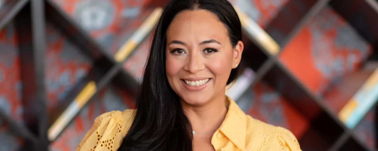 Brenda Arce, pictured here in a yellow blouse, is a Robert Half vice president and branch manager in Miami, Florida, and author of Kissed by the Sun.