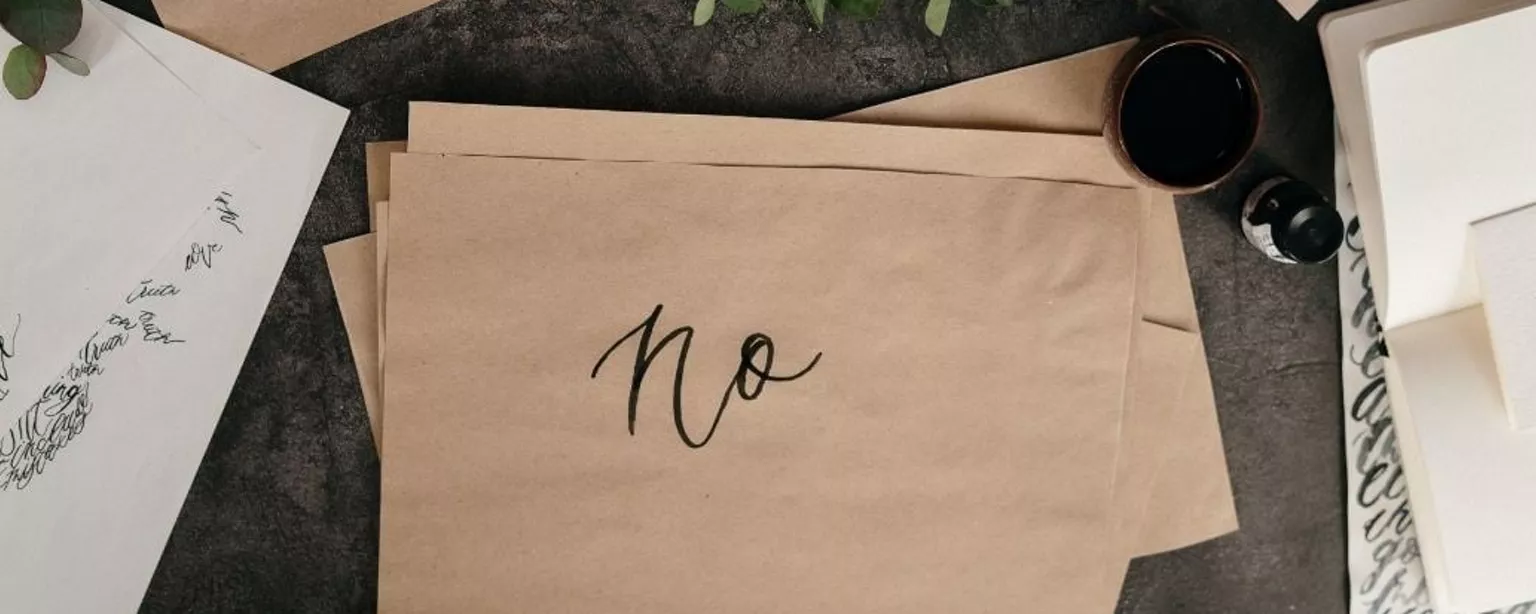 Schreibtisch mit braunem Papier, auf dem "No" steht