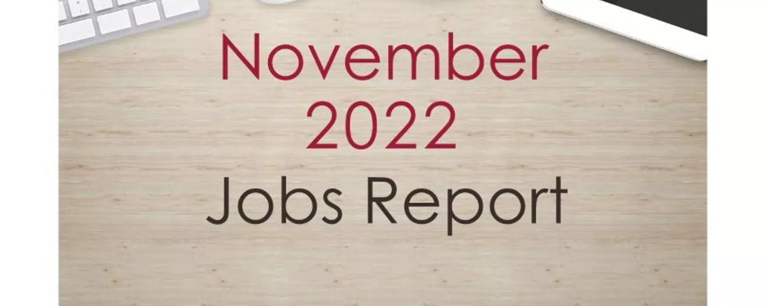 Desktop with keyboard, tablet and coffee cup, with text that reads: November 2022 Jobs Report.