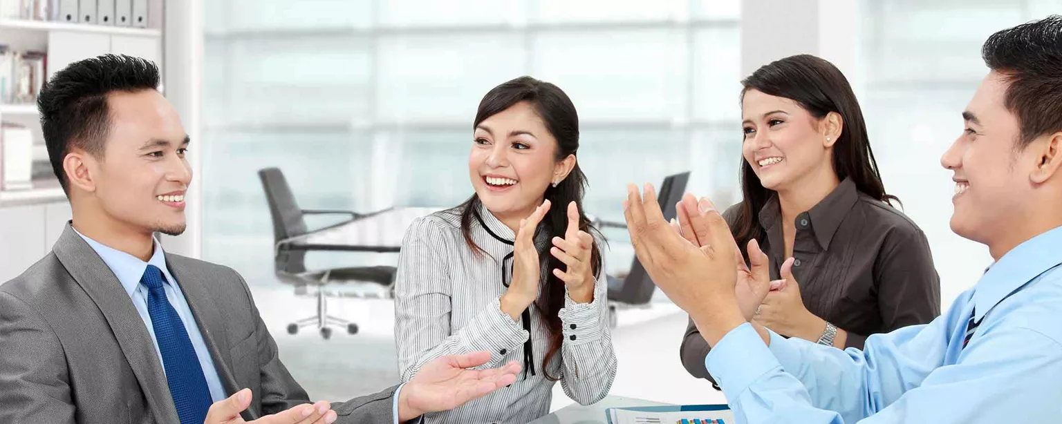 How to Build a Career in the Payroll Department — professional workers at table clapping for man