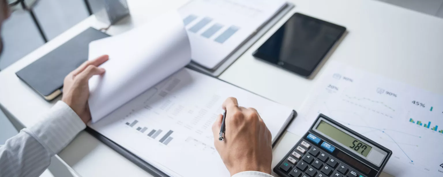 A career professional desk with financial documents, pen, and calculator.